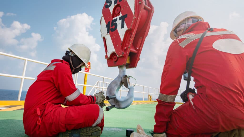 People in hardhats working on a rigging inspection