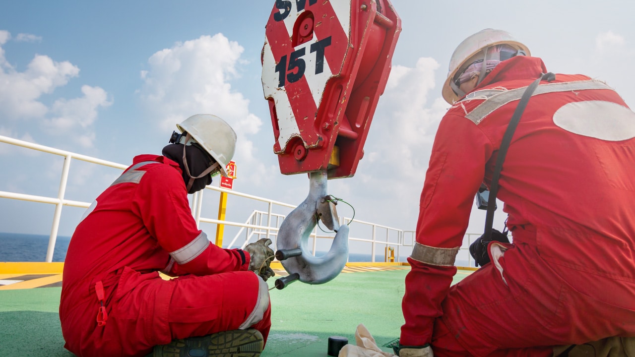 People in hardhats working on a rigging inspection